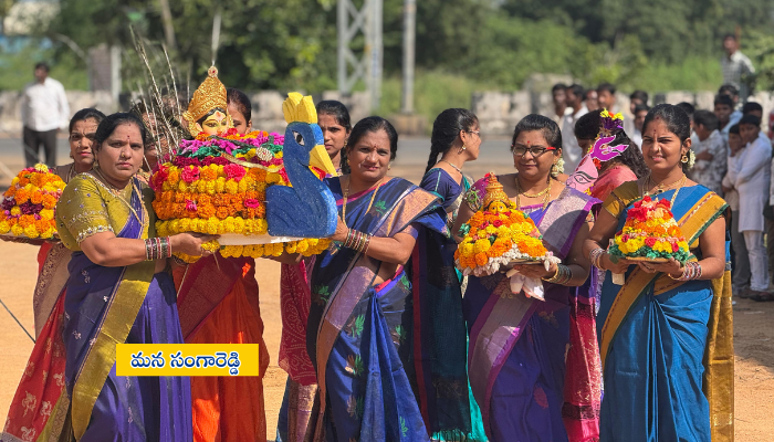 Students and teachers in traditional attire celebrating Bathukamma festival with colorful flower arrangements at Rao’s International School, Sadashivpet